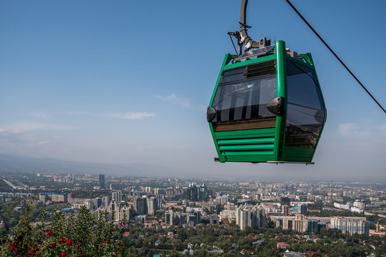 Gondola Cable-car lift on Kok Tobe hill over city of Almaty in Kazakhstan with panoramic view of Almaty City centre in summer