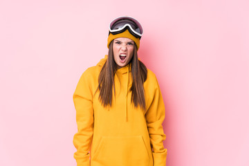 Young caucasian skier woman isolated screaming very angry and aggressive.