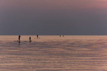 Fototapeta na wymiar Stand up paddle boarding on quiet sea