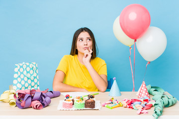 Young caucasian woman organizing a birthday looking sideways with doubtful and skeptical expression.