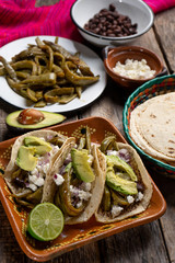 Mexican grilled nopal cactus tacos with cheese and avocado on wooden background