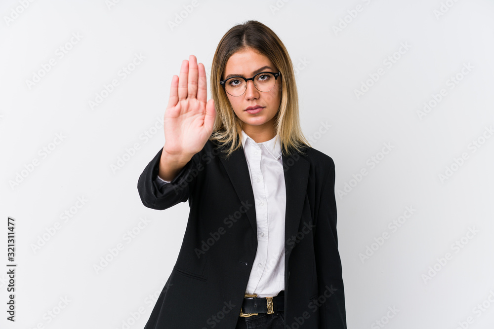 Wall mural Young business caucasian woman standing with outstretched hand showing stop sign, preventing you.