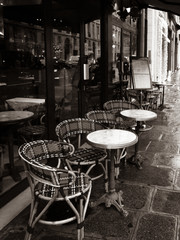 Paris, France, Parisian cafe, tables and chairs on paved sidewalk, black and white photo.