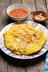 Spanish scrambled eggs with potatoes called tortilla or tapa on wooden background