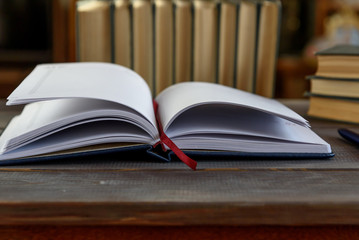 Open note book with pen and books on a wooden table. University exam preparation concept.