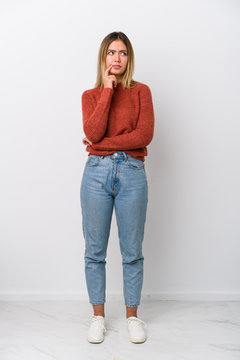 Full Body Young Caucasian Woman Looking Sideways With Doubtful And Skeptical Expression.