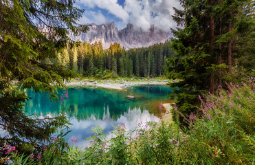 Wonderful summer view of Carezza or Karersee lake. Amazing morning scene of Dolomiti Alps, Province of Bolzano, South Tyrol, Italy, Europe. Popular travel location. Picture of wild area.