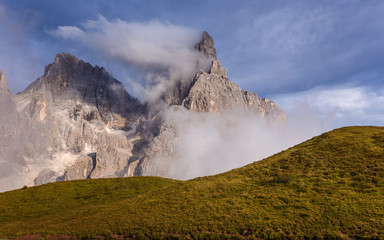 Incredible nature landscape in sunny day. Majestic Cimon della Pala peak in clouds during sunset. Amazing natural scenery in Dolomites Alps. Picture of wild area.