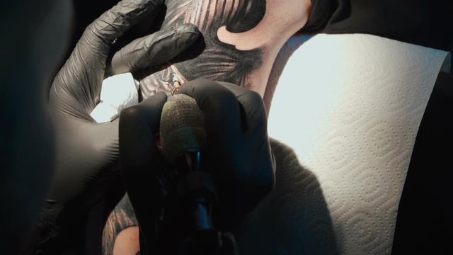 Close up video of doing tattoo of snake on woman in studio