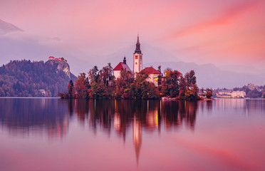Fototapeta na wymiar Scenic image of Fairytale lake Bled during sunset. Natural summer scenery with colorful sky. Fantastic Picturesque Scene over famouse lake. Julian Alps. Slovenia. Wonderful Autumn landscape.