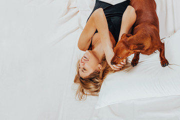 happy beautiful girl wakes up in fasting, dog wakes up his mistress early in the morning 