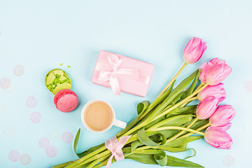 View from above tulips and gift box on blue. Background for womens day, 8 March Valentines day, 14 february. Flat lay style, top view, mock up, template, overhead. Greeting card