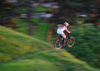 Young man jump with mountain bike across the edge