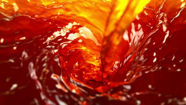 Super slow motion of pouring apple juice or ice tea drink in twister shape. Filmed on high speed cinema camera, 1000 fps.