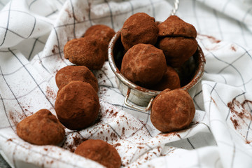 Chocolate candy truffles and chocolate pieces on the napkin. Tasty confectionery collection. Close up view. Selective focus