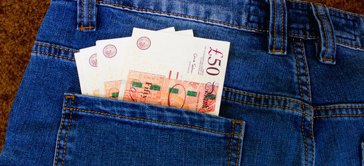 Money in the pocket of jeans. English pounds
