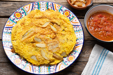 Spanish scrambled eggs with potatoes called tortilla or tapa on wooden background