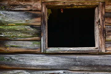 A window without glass on the wall of an old barn.