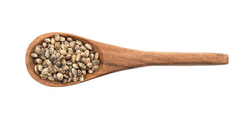 Brown wooden spoon with hemp seeds seen directly from above and isolated on white background