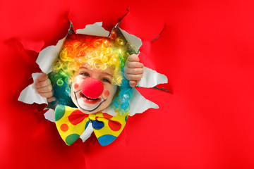 Child With Clown Costume Going Through A Paper Hole