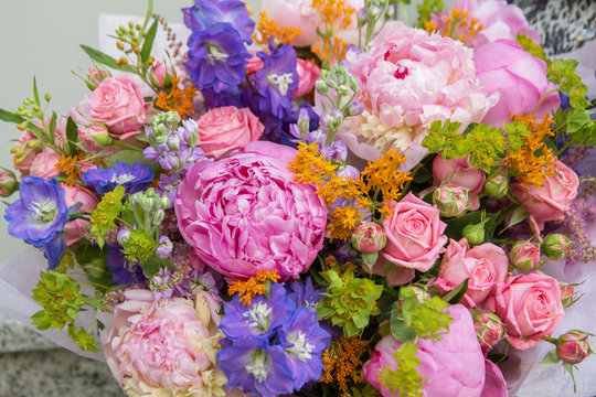 Big pink purple bouquet by florist with different flowers and roses close-up