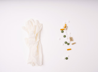 Medical pills, capsules and medicine disposable gloves isolated on white background. Top view. Copy space.
