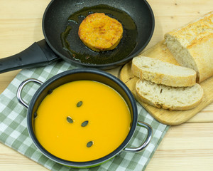 Kürbissuppe im Topf und Bratling in der Pfanne
