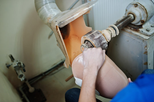 Prosthetist man making prosthetic leg while working in laboratory.