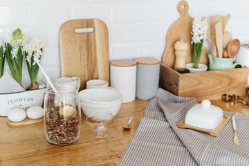 Fototapeta na wymiar Kitchen utensils and dishware spring flowers on wooden table.