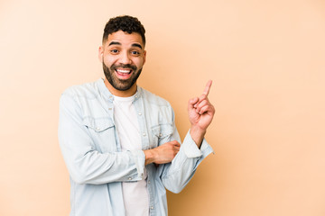 Young mixed race arabic man isolated smiling cheerfully pointing with forefinger away.