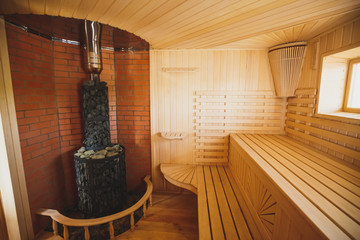 Light, spacious sauna made of natural wood with a sauna heater