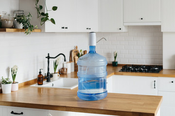 A larger bottle of clean water 19 liters with automatic white pomp in the interior of the apartment...