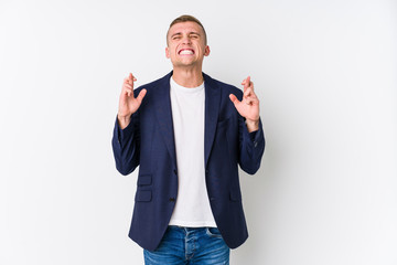 Young business caucasian man crossing fingers for having luck