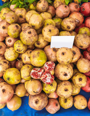 Closeup view of turkish fresh organic pomegranates selling in market. White blank empty paper card...
