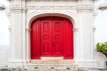 Fototapeta na wymiar red door on white facade