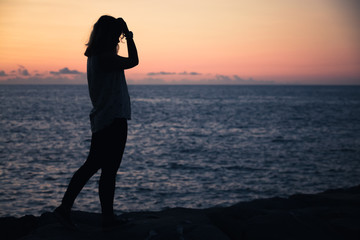 Fototapeta na wymiar Silhouette photo of a teenage girl standing at beach