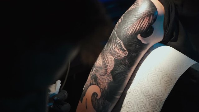 Close up video of man doing black tattoo on woman