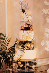 White wedding cake decorated by flowers. Wedding. Reception. Wedding cakes, close up, photography. A multi level white wedding cake