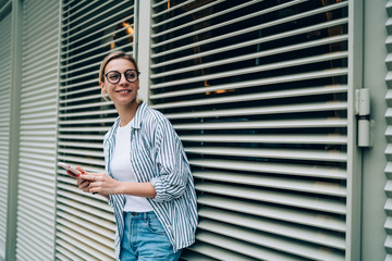 Beautiful lady smiling and leaning on window blind