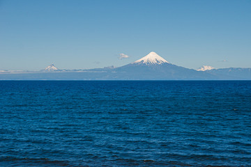 volcano motorboat boat osorno cabulco villarica chile volcan thaw river snow on top chile puerto varas puerto mont pucon villarica osorno blue water blue sky sunset lagun photo Jovani Prochnov