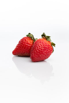 Two organic strawberry fruits isolated on a white background
