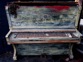 A lonely old piano on city streets. Interior of a big city.