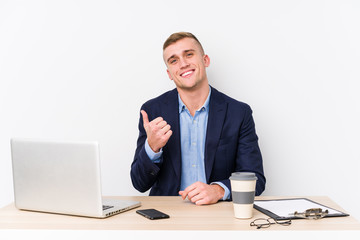 Young business man with a laptop smiling and raising thumb up