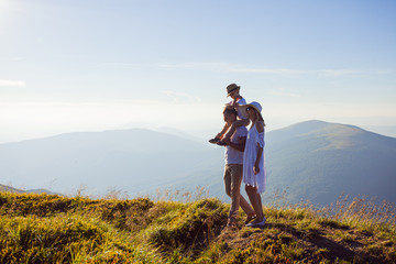 Fototapeta premium The family admires the mountain landscape during walking