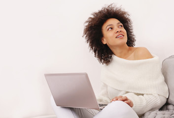 Happy casual beautiful woman working on a laptop, sitting on bed at home. Cozy , casual style