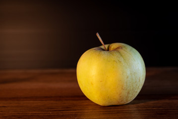 yellow and green apple on a wooden table
