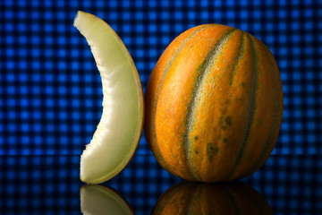 pop art. Melon and a slice of melon with reflection on a blue background. Free space for text.
