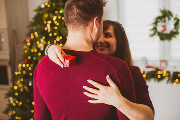 Back view couple embracing near Christmas tree