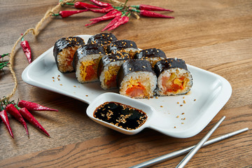 Korean traditional rolls - Gimbap with boiled rice and other ingridients on a white plate on a wooden background. Selective focus. Tasty street food