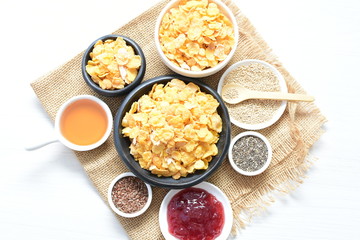 Cereal flakes without sugar, accompanied by seeds, jam and honey